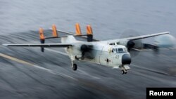 FILE - A C-2A Greyhound logistics aircraft lands on the flight deck of the aircraft carrier USS Harry S. Truman, Sept. 30, 2015.