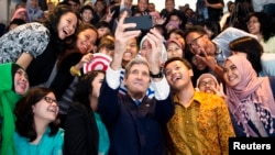 Menteri Luar Negeri John Kerry mengambil 'selfie' bersama sejumlah mahasiswa/i Indonesia sebelum berpidato di Jakarta (16/2). (Reuters/Evan Vucci)