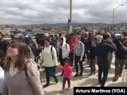 Members of the Central American migrants caravan arrive at the "El Chaparral" pedestrian crossing on their way to U.S. Customs and Border Patrol, at the U.S.-Mexico border in Tijuana, Mexico, April 29, 2018. (A. Martinez/VOA)