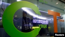 FILE - An investigator entering the Cyber Terror Response Center of the Korean National Police Agency is reflected on a window in Seoul.