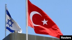 A Turkish flag flutters atop the Turkish embassy as an Israeli flag is seen nearby, in Tel Aviv, Israel, June 26, 2016.