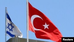 A Turkish flag flutters atop the Turkish embassy as an Israeli flag is seen nearby, in Tel Aviv, Israel, June 26, 2016.