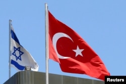 A Turkish flag flutters atop the Turkish embassy as an Israeli flag is seen nearby, in Tel Aviv, Israel, June 26, 2016.