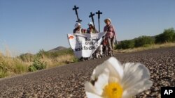 Aktivis pro-migran AS dan Meksiko berbaris di dekat kota Sasabe, Meksiko utara pada hari Senin tanggal 31 Mei 2004 dalam pawai melalui gurun Arizona untuk menarik perhatian pada apa yang mereka katakan sebagai kebijakan imigrasi yang cacat. (Foto: AP)