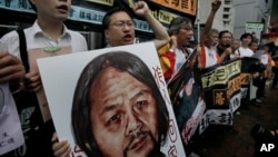 Protesters raise picture of Chinese dissident Tan Zuoren during outside Chinese government's liaison office, Hong Kong, June 9, 2010.