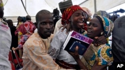One of the freed Chibok girls celebrates with family members during a church service in Abuja, Nigeria, Oct. 16, 2016. Twenty-one girls were released Thursday and flown to Abuja, Nigeria's capital, but it's taken days for relatives to arrive.s