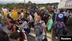 People break through the barricade set up by the Venezuelan guard to travel into the Venezuelan side on the Colombian-Venezuelan border over the Simon Bolivar international bridge in San Antonio, Venezuela, April 2, 2019. 
