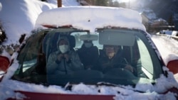 A volunteer from a migrant center drives migrants to where they need to go so they can take trains to Briançon on December 11, 2021. (AP Photo/Daniel Cole)