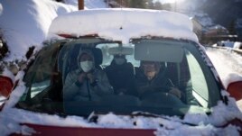 A volunteer from a migrant center drives migrants to where they need to go so they can take trains to Briançon on December 11, 2021. (AP Photo/Daniel Cole)