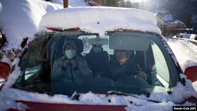 A volunteer from a migrant center drives migrants to where they need to go so they can take trains to Briançon on December 11, 2021. (AP Photo/Daniel Cole)