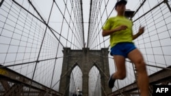 Seorang pelari berolahraga di Jembatan Brooklyn, New York, 19 Juni 2019. (Foto: AFP)