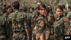Combatentes das forças apoiadas pelos EUA e lideradas Forças Kurdas Democráticas celebram em Omar, província síria de Deir Ezzor, 23 de Março, 2019, depois do anúncio da eliminação total do Estado Islâmico