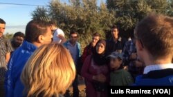 Refugees get instructions from an aid worker as they prepare to cross from Syria into Hungary.