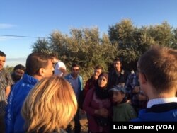 Refugees get instructions from an aid worker as they prepare to cross from Syria into Hungary.