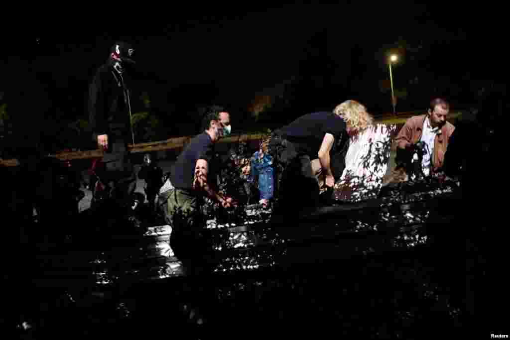  Demonstrators climb over a rail as they are being pushed off Interstate 580 during a demonstration following the election of Donald Trump as president of the United States, in Oakland, California, Nov. 10, 2016. 