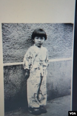远藤向记者展示5岁时摄于长春的照片，她说这是在国共内战时期长春一场巷战之后拍摄的(美国之音歌篮拍摄)