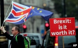 FILE - An anti-Brexit poster is seen in front of the Houses of Parliament in London, Sept. 4, 2018.