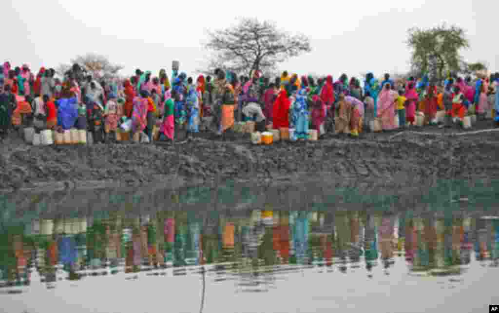 Displaced women gather to collect water from a water hole near Jamam refugee camp in South Sudan's Upper Nile State, March 10, 2012.