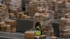 Workers walk past boxes to be shipped inside of an Amazon fulfillment center in Robbinsville, New Jersey, Nov. 27, 2017.