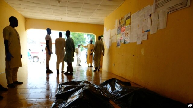 FILE - Family members wait to claim bodies of suicide attack victims at a hospital in Konduga, outside Maiduguri, Nigeria, Aug. 16, 2017. The attack was blamed on Boko Haram militants.