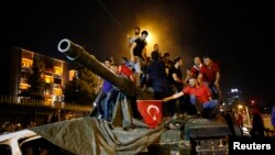 Warga berdiri di atas tank angkatan darat Turki di Ankara (16/7). (Reuters/Tumay Berkin)