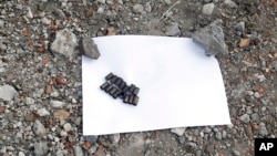 Bullet casings are seen in front of a mass grave near a local mine in the village of Nyzhnya Krynka, eastern Ukraine, Sept. 23, 2014.