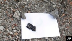 Các võ đạn được tìm thấy trước một hố chôn tập thể gần một khu mõ trong làng Nyzhnya Krynka, miền đông Ukraine, 23/9/14
