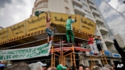 Manifestantes gritan consignas desde un andamio en una construcción durante una protesta contra el gobierno de Mauricio Macri en Buenos Aires, Argentina. Miércoles 21 de febrero de 2018.