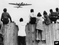 West Berlin children at Tempelhof airport watch fleets of U.S. airplanes bringing in supplies to circumvent the Russian blockade in this undated photo. The airlift began June 25, 1948 and continued for 11 months. (AP Photo)