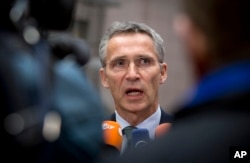 NATO Secretary General Jens Stoltenberg speaks with the media as he arrives for a meeting with European Union defense ministers at the EU Council building in Brussels, Nov. 18, 2014.