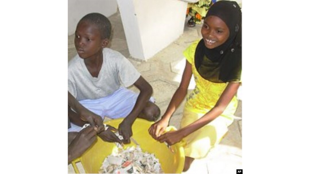 Students tear paper before making paper briquettes, Diourbel, Senegal, December 5, 2011.