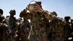 An Afghan Army soldier adjusts his helmet at a training facility near Kabul, May 8, 2013 (AP Photo/Anja Niedringhaus, File) May 8, 2013