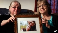 Người thân cầm ảnh của Joshua Boyle và Caitlan Coleman, cặp vợ chồng bị Taliban bắt cóc cuối năm 2012. (Ảnh tư liệu)