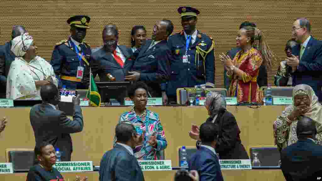 Le président zimbabwéen Robert Mugabe (troisième à gauche), en cravate rouge, en présence de la présidente de la Commission de l&#39;Union africaine, Nkosazana Dlamini Zuma (à gauche), et du secrétaire général de l&#39;ONU Ban Ki-moon (à droite), passant le relais à son successeur, le nouveau président de l&#39;Union africaine, le chef de l&rsquo;Etat tchadien Idriss Deby (quatrième à gauche), au Sommet de l&#39;Union africaine à Addis-Abeba, 30 janvier 2016.