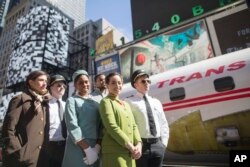 Para aktor mengenakan busana pilot, awak kabin, dan mekanik dari tahun 1960an dan 70an. Mereka berpose di samping Lockheed Constellation L-1649A Starliner, atau dikenal dengna nama “Connie, yang parkir di Times Square di New York, untuk acara promosi, Sabtu, 23 Maret 2019.