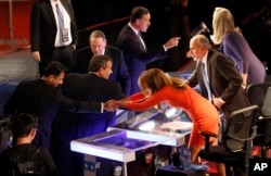 Bobby Jindal, left, Chris Christie, Mike Huckabee and Rick Santorum talk to moderators Trish Regan, Gerald Seib and Sandra Smith, right, after a Republican presidential debate at Milwaukee Theatre, Tuesday, Nov. 10, 2015, in Milwaukee.