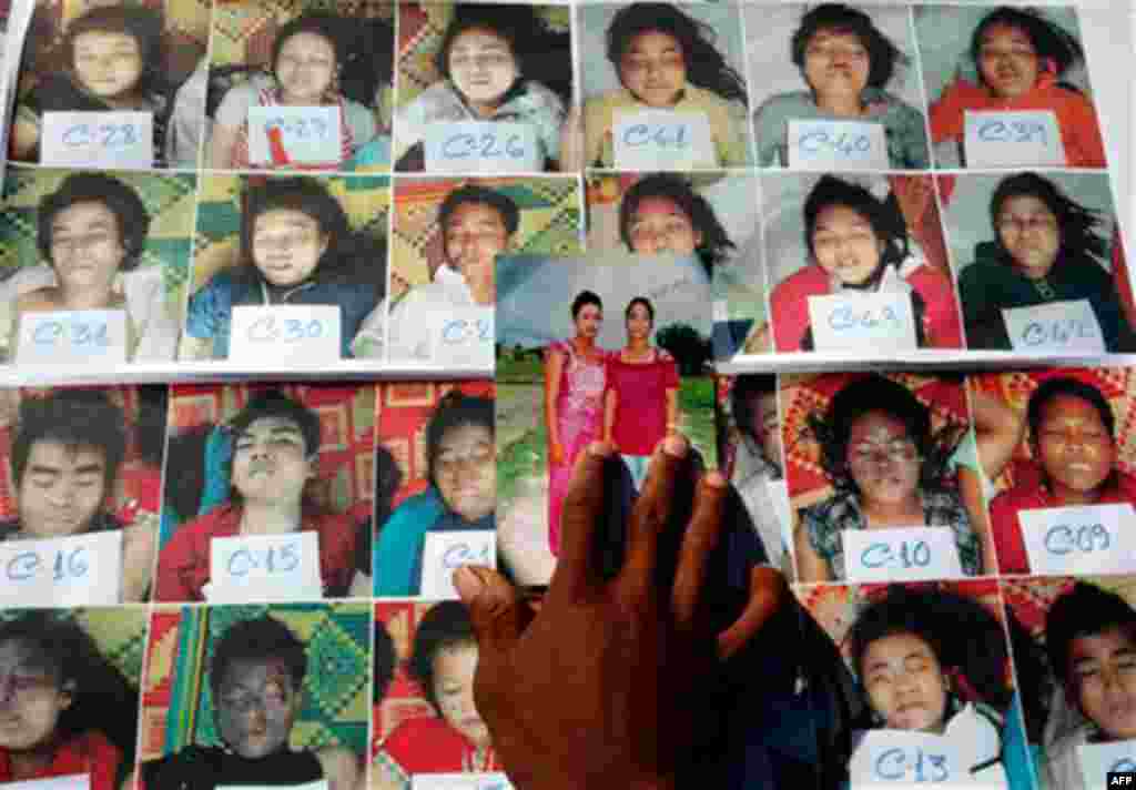 A Cambodian man compares a photo to those of stampede victims at Preah Kossamak Hospital in Phnom Penh, Cambodia, Wednesday, Nov. 24, 2010. Thousands of people stampeded during a festival in the Cambodian capital late Monday, leaving over three hundred de