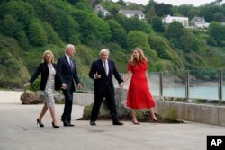 President Joe Biden and first lady Jill Biden are greeted and walk with British Prime Minister Boris Johnson and his wife Carrie Johnson, ahead of the G-7 summit, Thursday, June 10, 2021, in Carbis Bay, England. (AP Photo/Patrick Semansky)