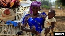 FILE - A United Nations report predicts a baby boom in Africa. Here, a woman carries her child in Nigeria's Kaduna State. 