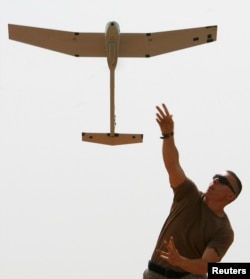 FILE - A soldier with the U.S. Army's 10th Mountain Division launches a remote controlled Raven observation drone from a military base in Mahmudiya, south of Baghdad, April 28, 2007.