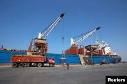 FILE - Workers unload aid shipment of wheat from St. George ship, at the Red Sea port of Hodeidah, Yemen, Nov. 30, 2017.