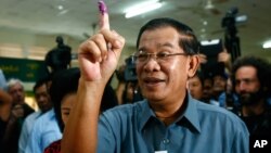 PM Kamboja Hun Sen menunjukkan jarinya setelah memberikan suara di TPS kota Takhmau, selatan ibukota Phnom Penh (28/7). 