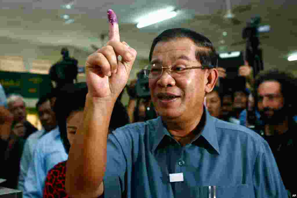 Cambodia's Prime Minister Hun Sen shows his inked finger after casting his ballot in Takhmau town, south of Phnom Penh, Cambodia, July 28, 2013. Hun Sen has been on the job for 28 years.