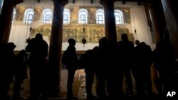 In this Thursday, Dec. 6, 2018 photo, visitors stand bellow a renovated part of a fresco inside the Church of the Nativity, built atop the site where Christians believe Jesus Christ was born, in the West Bank City of Bethlehem. (AP Photo/Majdi Mohammed)