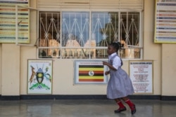 A Student runs on the verandah of the classrooms block on day one of opening schools in Kampala, Uganda, Jan. 10, 2022.