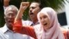 FILE - Nurul Izzah Anwar, right, daughter of imprisoned Malaysian opposition leader Anwar Ibrahim, leads a chant in Kuala Lumpur, March 17, 2015. 