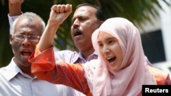 FILE - Nurul Izzah Anwar, right, daughter of imprisoned Malaysian opposition leader Anwar Ibrahim, leads a chant in Kuala Lumpur, March 17, 2015. 