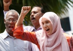 FILE - Nurul Izzah Anwar, right, daughter of imprisoned Malaysian opposition leader Anwar Ibrahim, leads a chant in Kuala Lumpur, March 17, 2015.