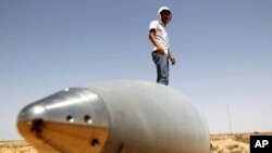An anti-Gaddafi fighter stands on an SA-5 SAM missile in Burkan air defense military base, which was destroyed by a NATO air strike in August, 2011.