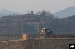 FILE - Military guard posts of North Korea, rear, and South Korea, bottom, are seen in Paju, near the border with North Korea, South Korea, Jan. 8, 2016.